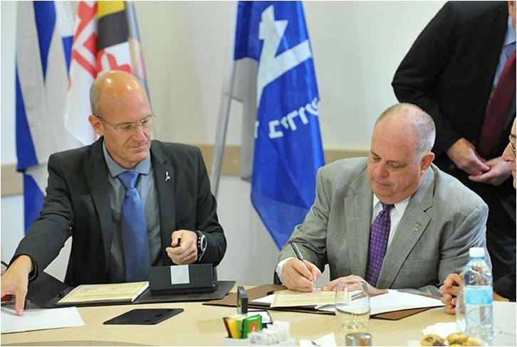 Maryland Governor Larry Hogan (R) signs the agreement during his 9-day trade mission to Israel (photo credit: Bruno Charbit)